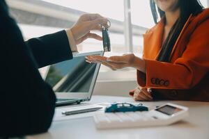 detailopname Aziatisch mannetje mensen auto verkoper of verkoop manager aanbiedingen naar verkopen een auto en legt uit en leest de voorwaarden van ondertekening een auto contract en verzekering. foto