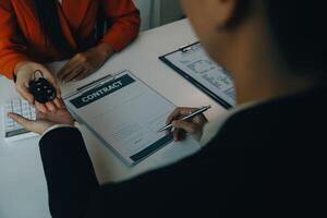 detailopname Aziatisch mannetje mensen auto verkoper of verkoop manager aanbiedingen naar verkopen een auto en legt uit en leest de voorwaarden van ondertekening een auto contract en verzekering. foto