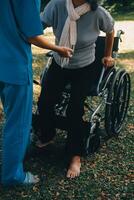 jong Aziatisch fysiek therapeut werken met senior vrouw Aan wandelen met een wandelaar foto
