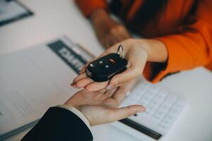 detailopname Aziatisch mannetje mensen auto verkoper of verkoop manager aanbiedingen naar verkopen een auto en legt uit en leest de voorwaarden van ondertekening een auto contract en verzekering. foto