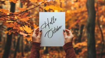 ai gegenereerd handen Holding een vel van papier met de woord oktober in herfst bladeren achtergrond foto