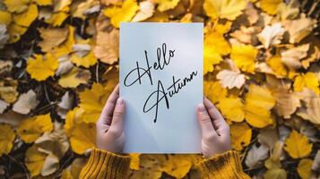 ai gegenereerd Hallo herfst. Mens Holding kaart met Hallo herfst belettering Aan geel bladeren achtergrond. foto