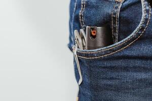 een mes en een gas- bus in de zak- van jeans, de concept van elke dag dragen foto