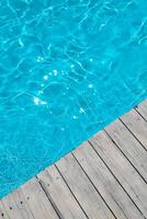 azuur transparant structuur van water in een blauw zwembad met spatten van de zon foto