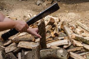Holding een mes naar besnoeiing brandhout foto
