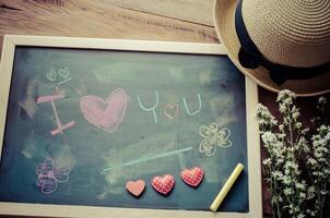 schoolbord met woorden geschreven in schok dat de ik liefde u en een bloemen hart was geplaatst De volgende naar de bord - de concept van Valentijnsdag dag. foto