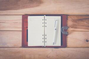 lege notebook met pen op houten tafel foto