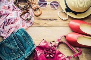 accessoires voor tiener- meisje Aan haar vakantie, hoed, elegant voor zomer zonnebril, leer tas, schoenen en kostuum Aan houten vloer. foto