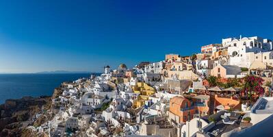 Grieks eiland van Santorini. verbazingwekkend reizen panorama, wit huizen, trap en bloemen Aan de straten. idyllisch zomer vakantie, stedelijk landschap, toerisme bestemming toneel. oei, thira panoramisch keer bekeken foto