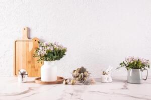 elegant keuken achtergrond voor Pasen dag met vazen van lila voorjaar bloemen, kom met kwartel eieren. natuurlijk producten, milieuvriendelijk keuken. foto