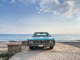 toneel- schot van een klassiek auto geparkeerd Aan de strand foto