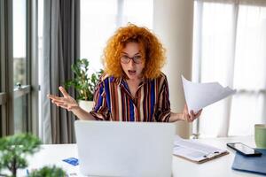 geschokt bedrijf vrouw gebruik makend van laptop Bij huis, op zoek Bij scherm, chatten, lezing of schrijven e-mail, zittend Aan bank, vrouw leerling aan het doen huiswerk, werken Aan Onderzoek project online foto