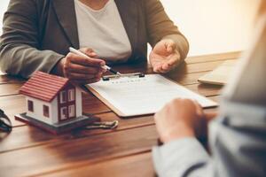 huis ondertekenaars ondertekening handtekening lening document naar huis eigendom met echt landgoed agenten eigendom. hypotheek en echt landgoed eigendom investering, huis verzekering foto