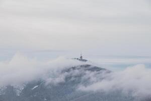 hoogste top van beskydy bergen lysa hora onder de ochtend- mist en wit sneeuw omslag. winter maanden Aan planeet aarde foto