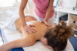 professioneel massage therapeut behandelen terug van cliënt foto