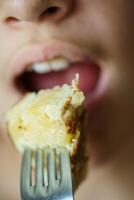 detailopname van meisje over naar eten heerlijk aardappel omelet van vork foto