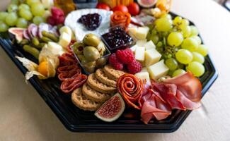 vleeswaren bord met vers fruit, vlees, en kaas foto