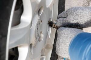 hand- houdt de druk peilen en vult de auto banden met lucht. auto onderhoud. foto