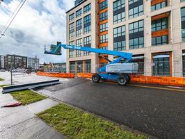 Portland, Verenigde Staten van Amerika - 27-01-2024 blauw werk platform tegen de achtergrond van een gebouw. mobiel kraan Bij een bouw plaats. foto