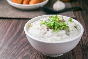 rijst- pap of congee met fijngehakt varkensvlees en zacht gekookt eieren foto