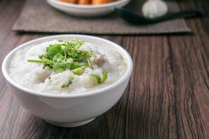 rijst- pap of congee met fijngehakt varkensvlees en zacht gekookt eieren foto