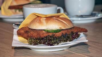 hamburger met vers salade, kaas en kotelet en een kop van koffie Aan een houten tafel. foto