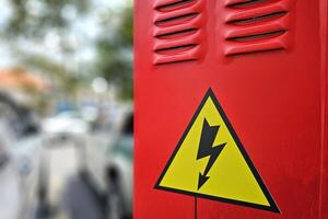 hoog Spanning teken Aan rood elektrisch controle doos. foto