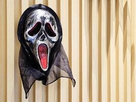 Bangkok, Thailand oktober 11, 2023 zwart schreeuwen carnaval masker Aan houten muur. schreeuw is een Amerikaans moord mysterie en slasher franchisenemer. foto