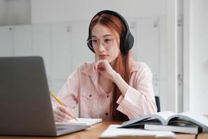 jong collage leerling gebruik makend van computer en mobiel apparaat aan het studeren online. foto