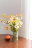 knus en elegant huis interieur met modern meubilair en elegant decor. toevoegen tintje van natuur met oranje en kunstmatig bloemen boeket in een wit vaas. luxe en ontspanning in woon- concept. foto