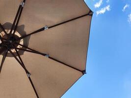 laag hoek visie van een geopend strand kleding stof paraplu tegen de blauw zonnig lucht, visie van onder parasol, vakantie of vakantie concept, met kopiëren ruimte foto