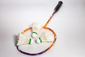 drie shuttles geplaatst Aan een badminton racket foto