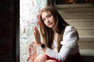 portret van tiener- meisje op zoek door de venster Bij een graffiti Aan de muur. foto