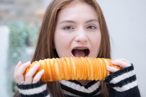 portret van tiener- meisje aan het eten brood in de keuken Bij huis foto