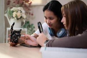 portret van tiener- meisjes studenten aan het studeren met robot model- in de leven kamer foto