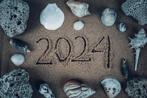 handgeschreven 2024 Aan schoon strand zand. gelukkig nieuw jaar foto