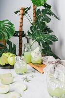 verfrissend heerlijk van bevroren guava sap in een glas en gesneden guava geplaatst Aan wit marmer, kamerplant groen fabriek achtergrond. decoratief samenstelling drankjes Bij huis . verticaal foto