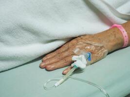 close-up van senior vrouw hand patiënt opgenomen in het ziekenhuis foto