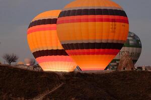 heet lucht ballon vlucht in Goreme in kalkoen gedurende zonsopkomst. rijden in een heet lucht ballon, de meest populair werkzaamheid in cappadocië. romantisch en beroemd reizen bestemming. foto