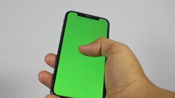 hand- Holding slim telefoon met groen scherm. geïsoleerd Aan wit achtergrond foto