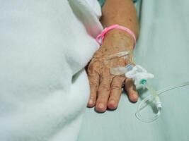 close-up van senior vrouw hand patiënt opgenomen in het ziekenhuis foto