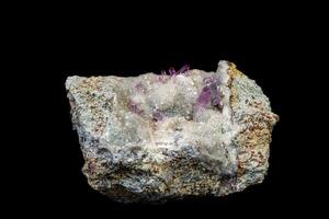 macro mineraal amethist steen in rots Aan een zwart achtergrond foto