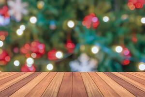 leeg hout tafel top met vervagen Kerstmis boom met bokeh licht achtergrond foto