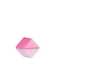 houten driehoek van roze kleur Aan een wit achtergrond foto