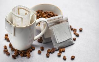 druppelen koffie zak met grond koffie in kop foto