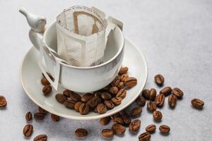 druppelen koffie zak met grond koffie in kop foto