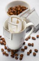 druppelen koffie zak met grond koffie in kop foto