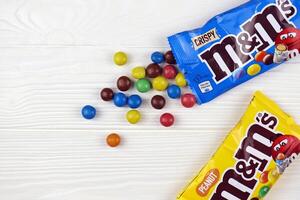 Charkov, Oekraïne - januari 2, 2021 m en Mevrouw kleurrijk knop vormig chocola snoepjes. multi gekleurde chocolaatjes elk van welke heeft de brief m gedrukt in lager geval in wit foto