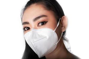close-up van een vrouw die een gasmasker opzet n95-masker ter bescherming tegen luchtwegaandoeningen als griep covid-19 coronavirus ebola pm2.5 stof en smog foto