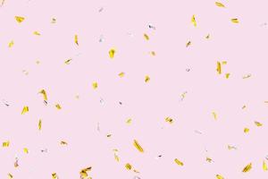 gouden zilveren sprankelende confetti geïsoleerd op roze achtergrond. vakantie-effect foto